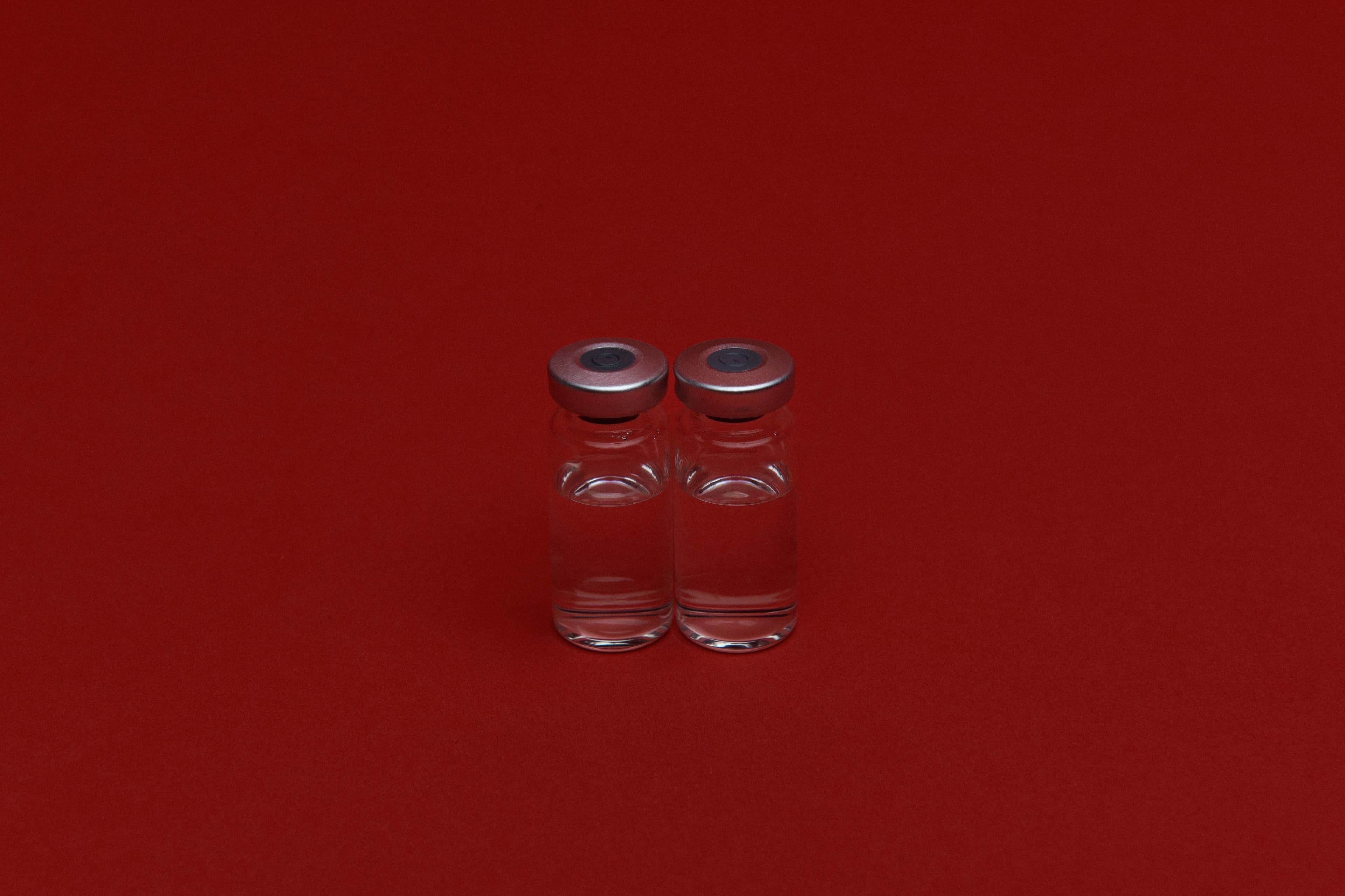 Small viles sitting on a red backdrop