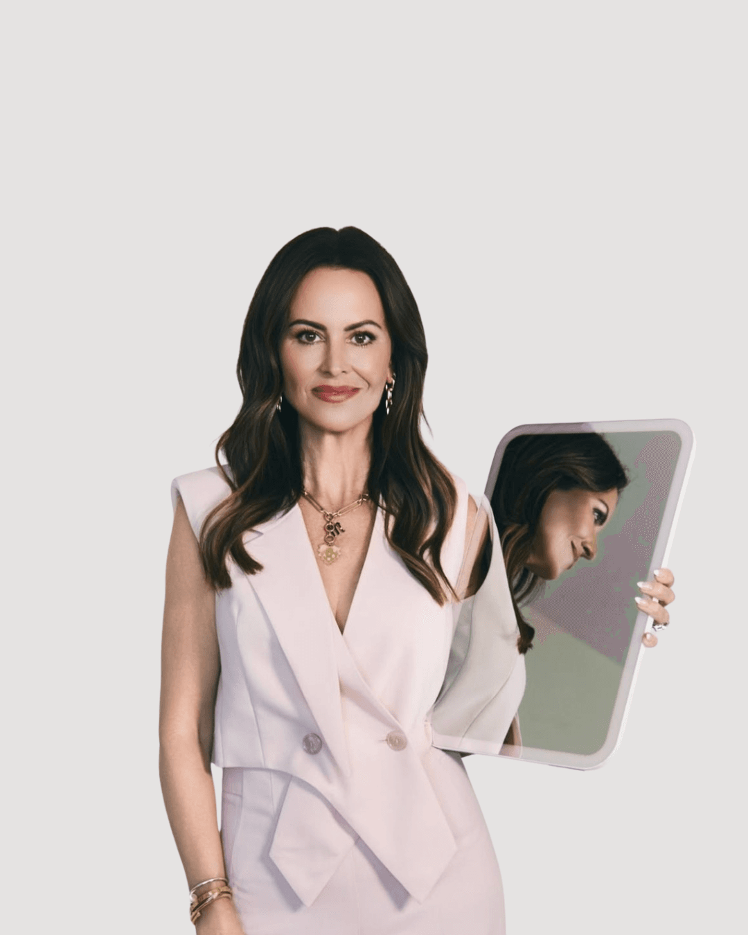 Woman on white background holding a mirror.